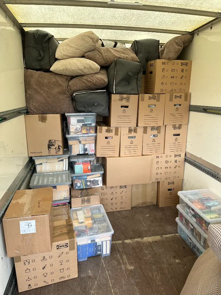 Packed boxes and blanket-wrapped furniture stacked neatly inside the removals van